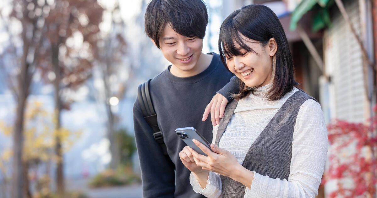 スマホを見ながら談笑する男女